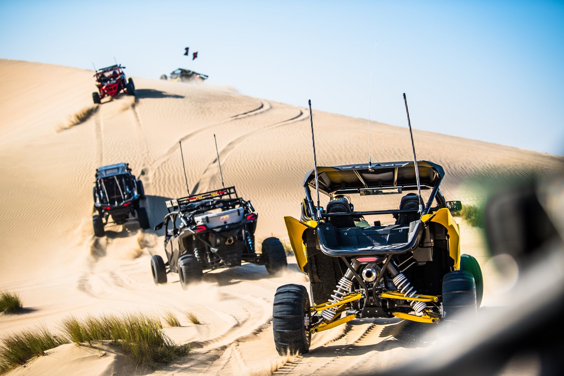 CanAm buggy Dubai driving across red sand dunes in the Dubai desert