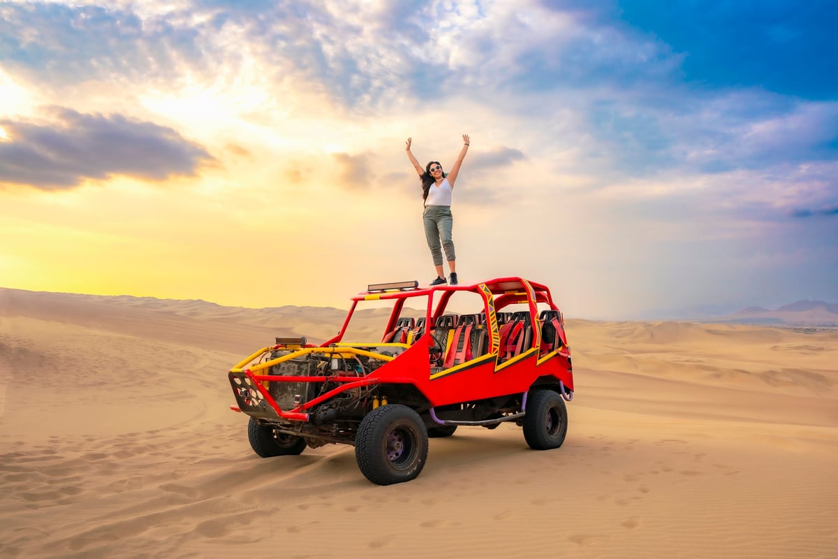 Young rider with a Polaris RZR 200 youth buggy in the Dubai desert at sunset