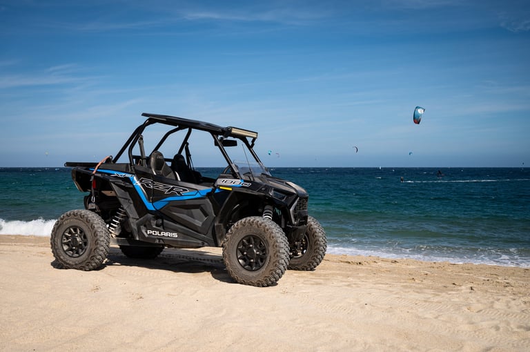 Polaris RZR XP 1000 all-terrain vehicle on beach with desert backdrop