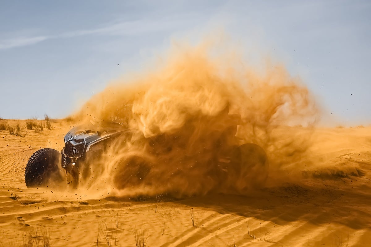 Polaris buggy climbing the tall red dunes of Big Red at Al Badayer in Dubai