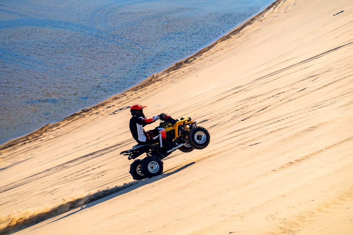 ATV riding through Dubai desert at high speed on open dunes