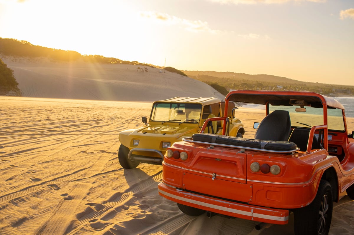 Buggies on steep sand dunes at sunset at Al Badayer Big Red
