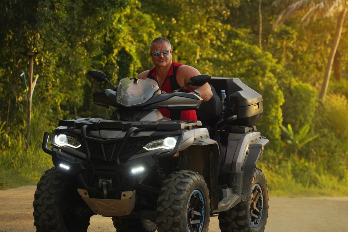 A man engages in extreme ATV riding on mountains in the morning.
