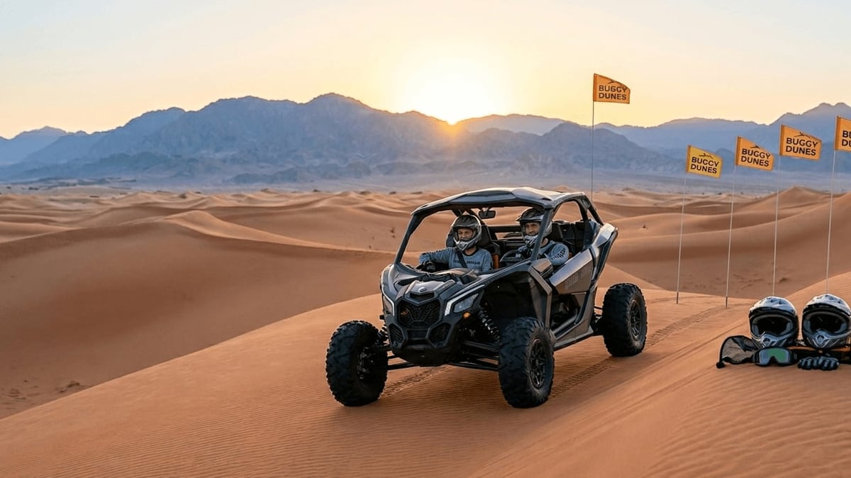 Black dune buggy parked on sand with mountains and flags visible in desert landscape at sunset